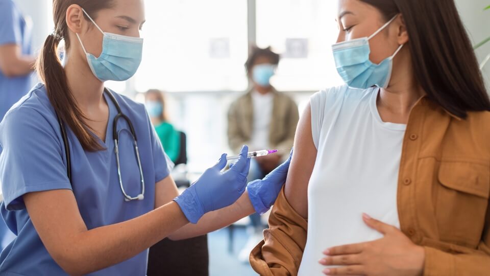 Medical staff about to insert a needle into a patient arm