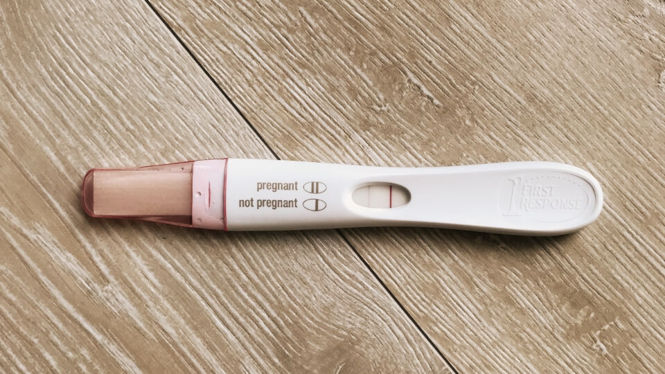Negative pregnancy test on wooden floor