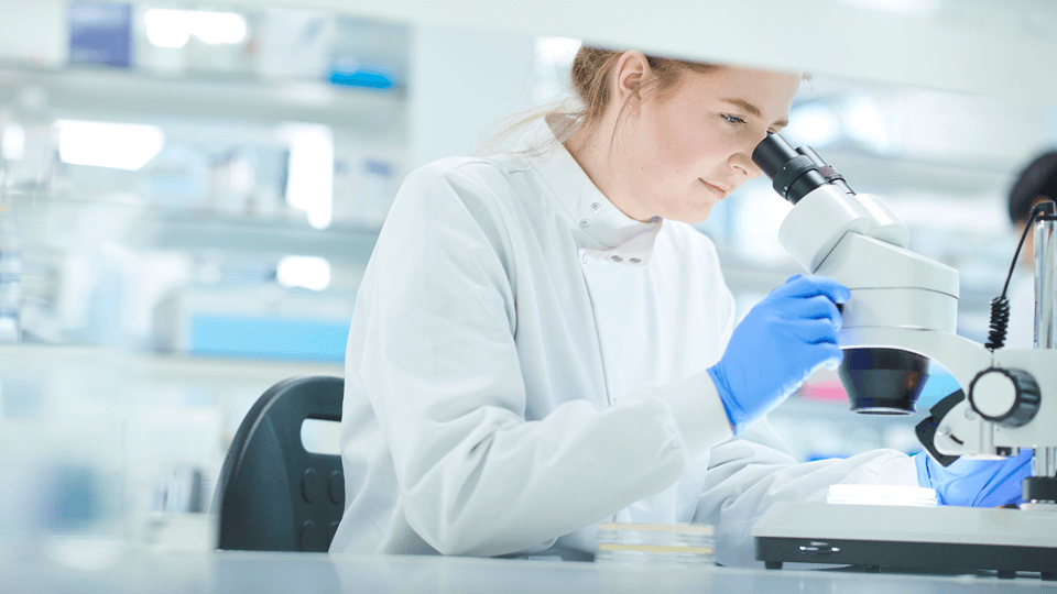 female scientist working in lab with a microscope